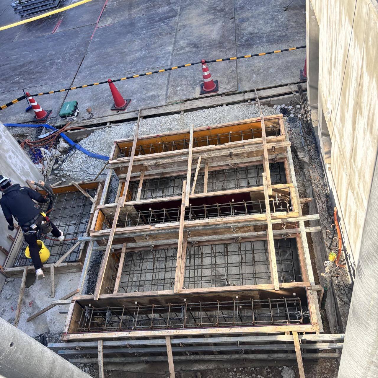 基礎の型枠を上から見下ろした写真。鉄筋の入った型枠のそばで職人が作業している